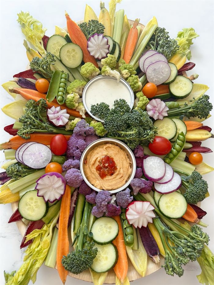 Colorful vegetable board with hummus and dip