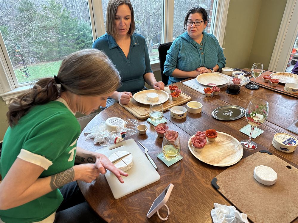 Guests building charcuterie boards around a table during a workshop