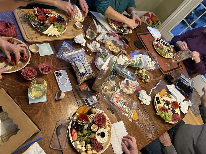 Workshop table covered in boards, ingredients and wine glasses